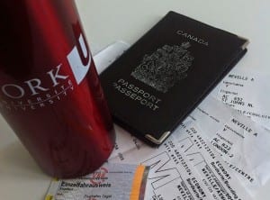 photo of Canadian passport, York University water bottle and several plane tickets