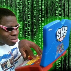Man wearing sunglasses smirking while typing on a toy computer. Multiples codes in green writing in the background.